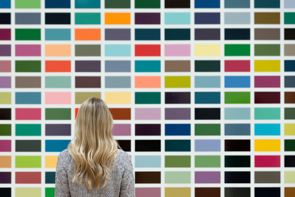 Ung kvinna tittar mot en vägg av färgval